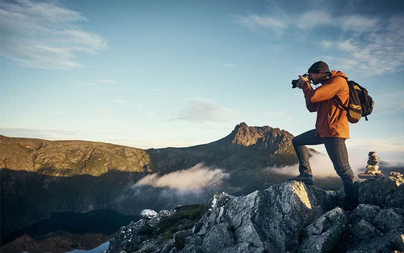 Outdoor photographer taking photo in mountains